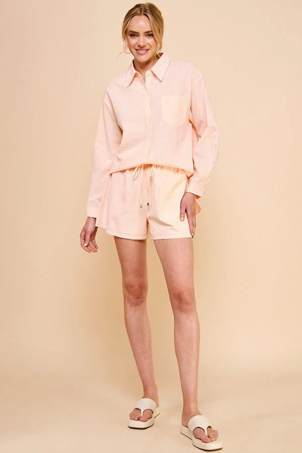 Woman in a pale pink stripe cotton blend button-up collar shirt and matching shorts