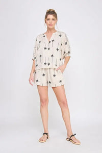 Woman wearing palm tree embroidered lined shorts and matching top for a stylish look