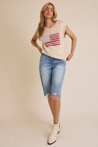 Woman wearing a patriotic shirt and denim capris showcasing the wide shoulder US USA flag sweater