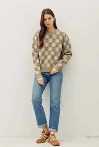 Woman wearing floral crew neck sweater with light wash jeans and sneakers