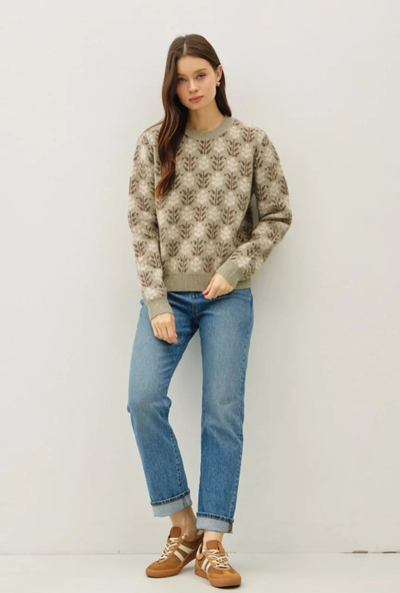 Woman wearing floral crew neck sweater with light wash jeans and sneakers