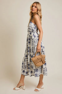 Woman wearing a halter neck abstract print dress in a patterned sundress style