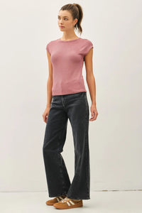 Woman wearing a pink ribbed cap sleeve T-shirt paired with black jeans