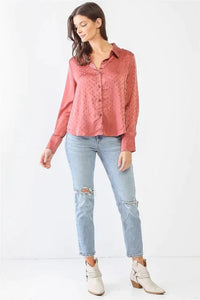 Woman in pink blouse and jeans featuring a flowy satin diamond print long sleeve top