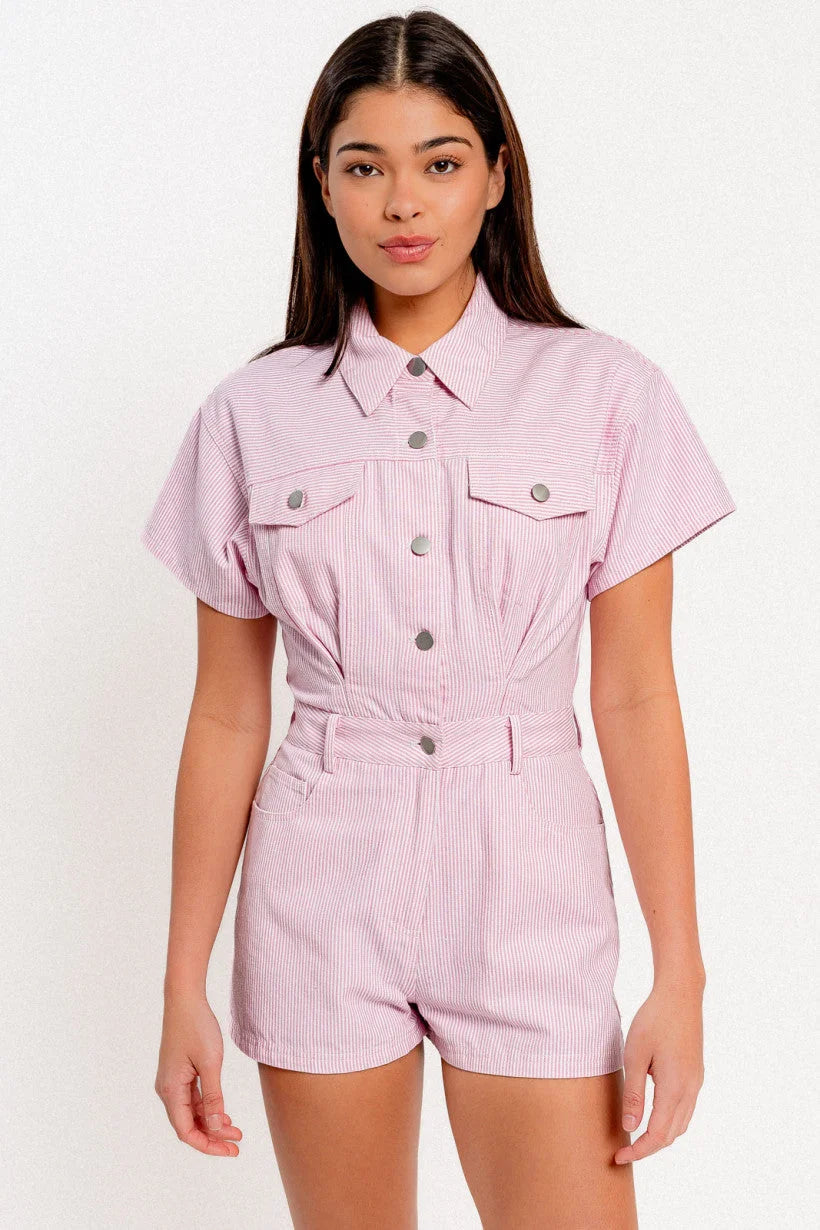 Woman in pink shirt and shorts modeling a stylish short sleeve denim romper