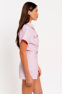 Woman in a pink shirt and shorts wearing a stylish short sleeve denim romper