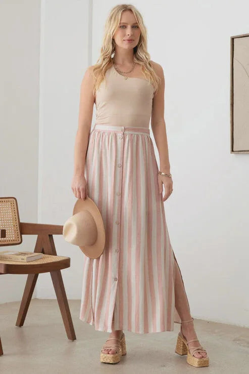 Woman in a pink and white striped maxi skirt with an elastic waist, showcasing boho style