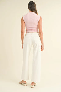 Woman in pink top and white pants wearing mid rise slim wide leg denim jeans