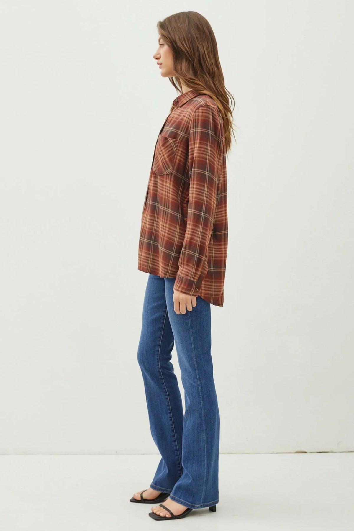 Woman in a classic button flannel shirt and blue jeans showcasing boho style