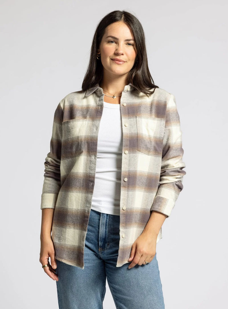 Smiling woman in flannel shirt with shirt tail hem and collared neckline, showcasing style