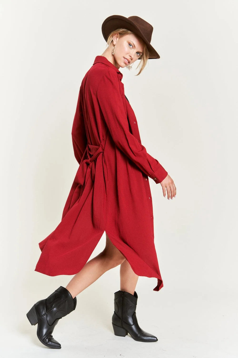 Woman in a red coat and hat showcasing a belted long dress with solid button details