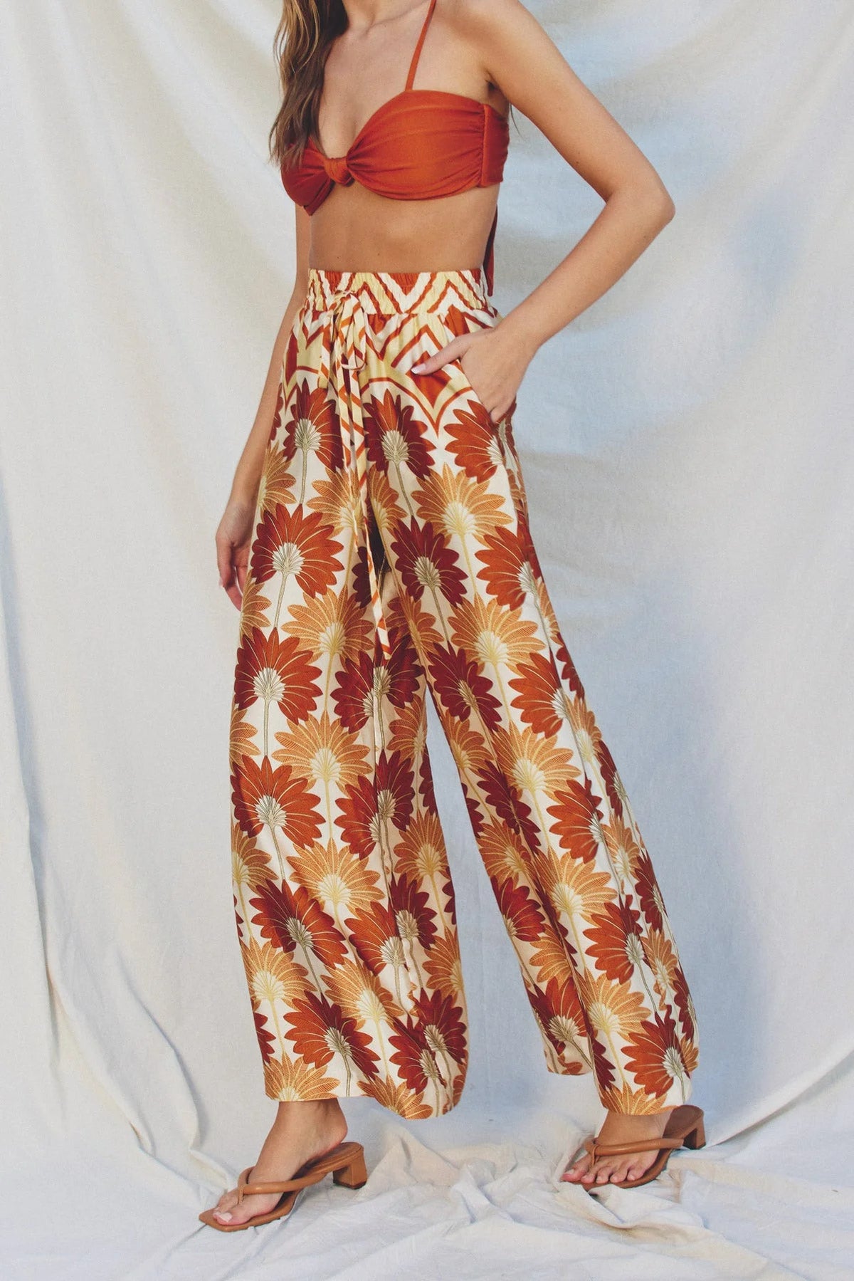 Woman wearing GOLDEN AGE WIDE LEG PULL ON PANTS in red and gold bohemian wide leg style