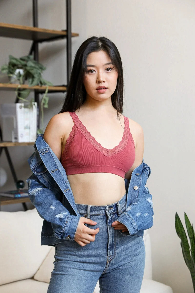 Woman in a red top and jeans showcasing the Lace Trim Padded Bralette, embodying feminine elegance