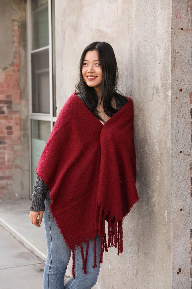 A woman in a red poncho shawl showcasing the Cozy Mohair Tassel Trim Blanket Scarf