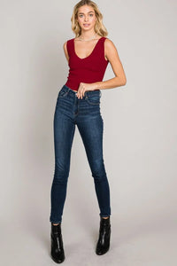 Woman in a red sleeveless top and blue jeans showcasing Bodycon Techno Rib V-Neck Tank