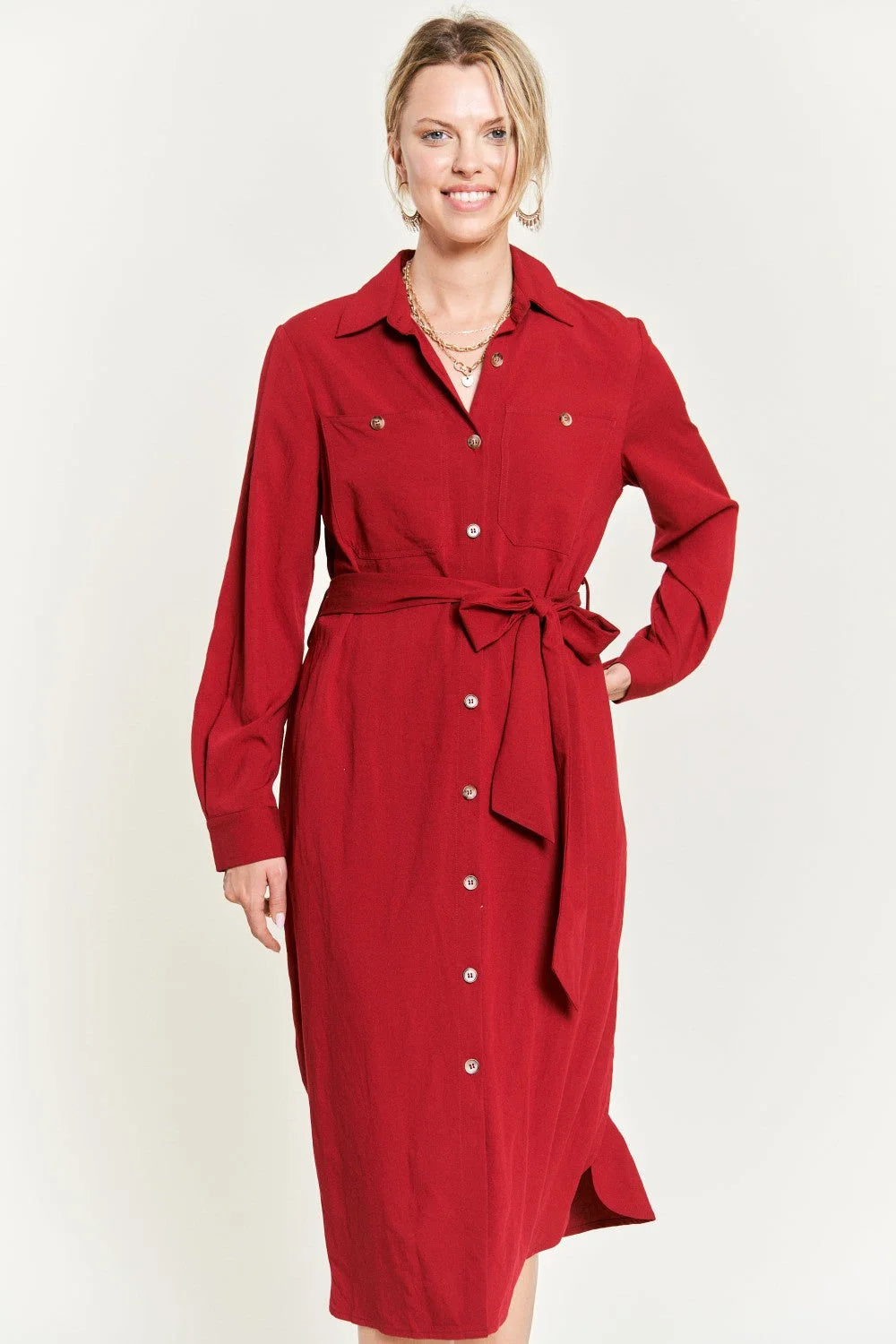 Woman in a red trench coat showcasing a SOLID BUTTON DOWN BELTED LONG DRESS