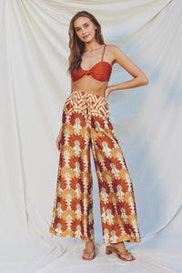 A woman in GOLDEN AGE WIDE LEG PULL ON PANTS with a red and yellow pattern