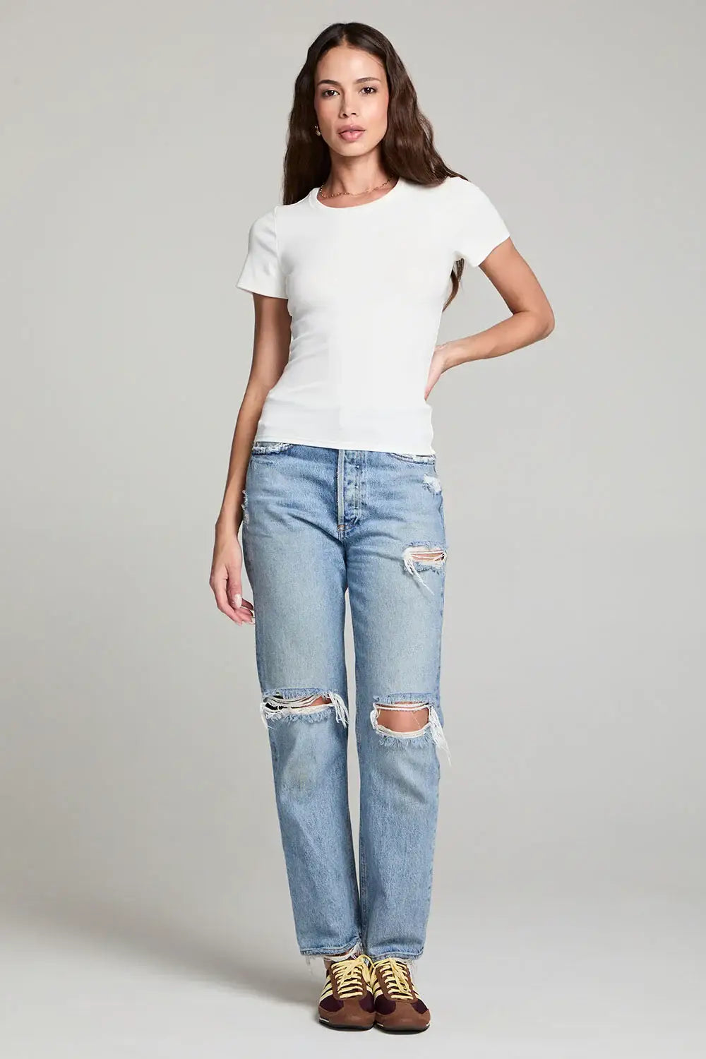 Woman in ripped jeans and white crew neck tee from Shop Daisy, showcasing women’s boho chic clothing