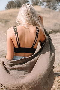 Woman sitting on a rock wearing Bohemian Eye Lace Applique Bralette, showcasing elegance