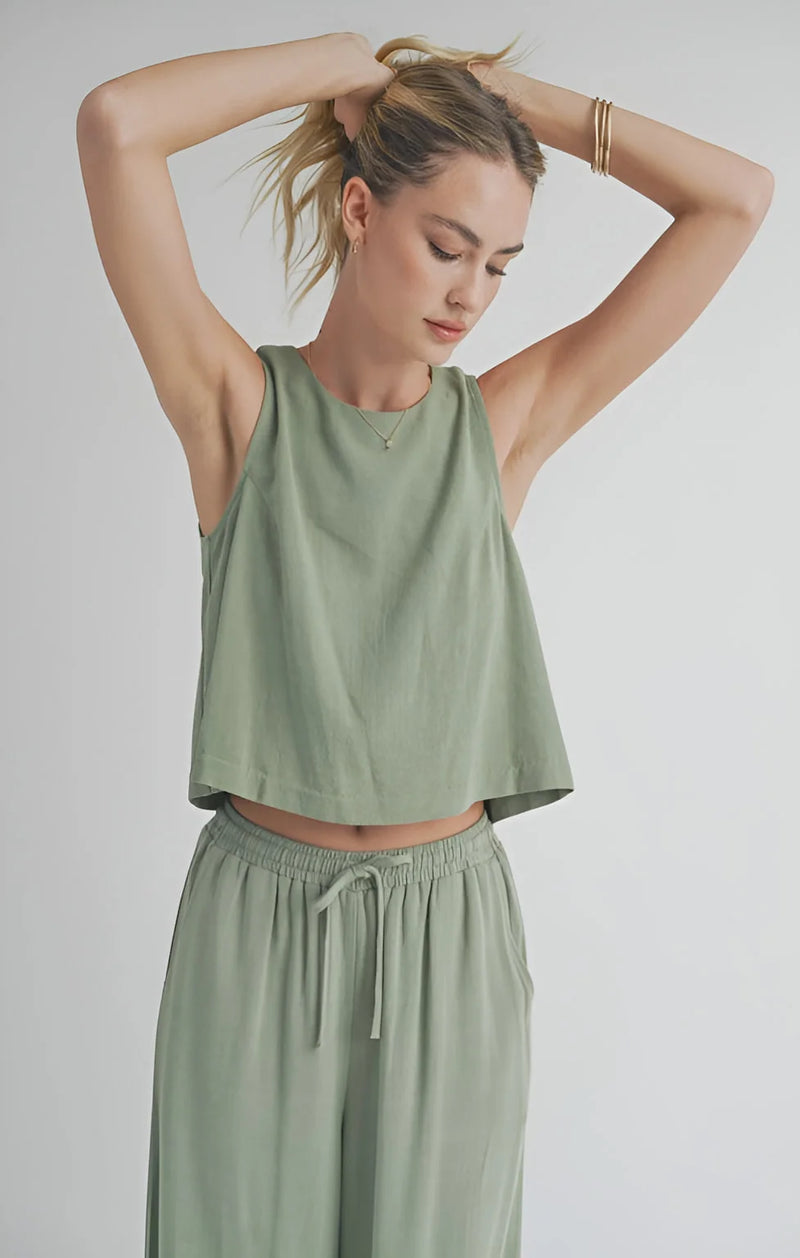 Woman in sage green Sugarloaf Linen Tank with matching drawstring pants