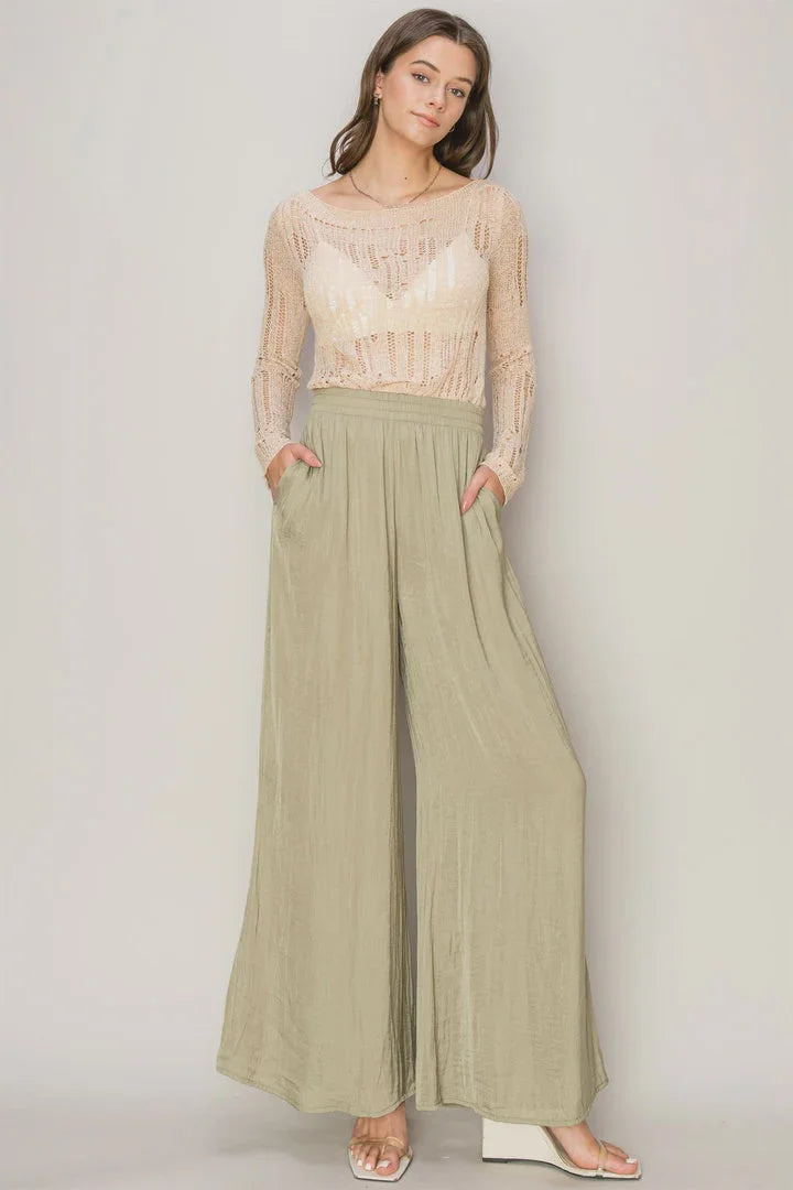 Woman in sheer lace top and flowy washed satin wide-leg sage green pants