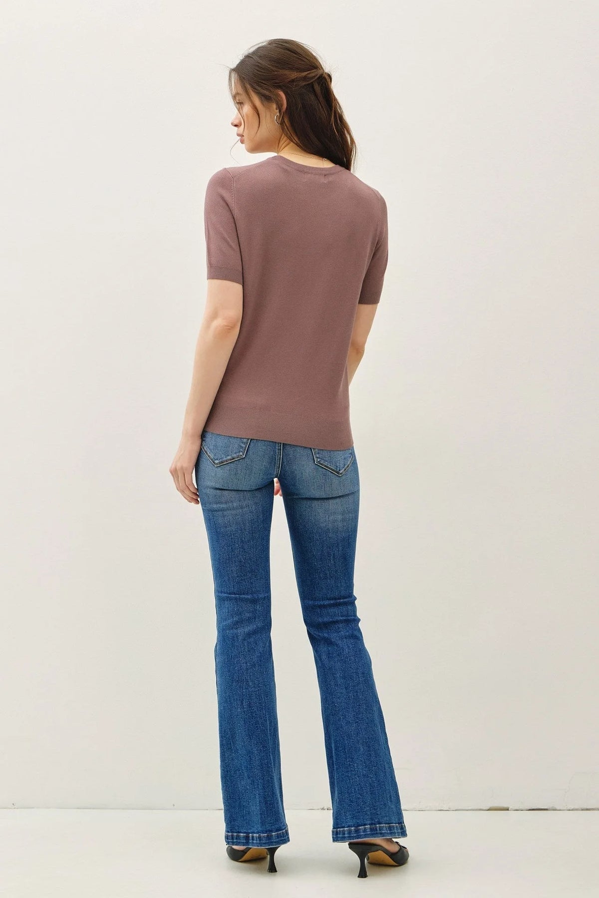 Woman modeling ultra soft short sleeve boho chic clothing in brown top and blue flared jeans