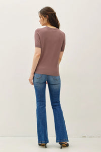 Woman modeling ultra soft short sleeve boho chic clothing in brown top and blue flared jeans
