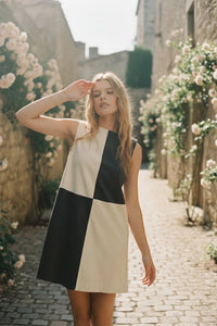 Woman wearing CORDUROY COLOR BLOCK MINI DRESS in black and cream, stylish block mini dress