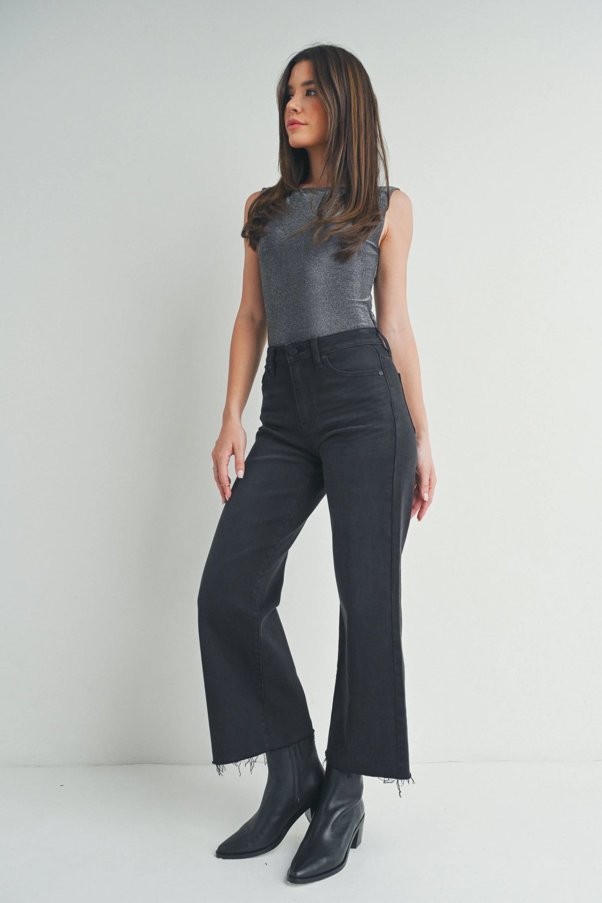 Woman in sleeveless gray top and wide-leg black pants, embodying boho free spirit style