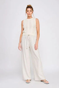 Woman wearing linen blend striped elastic tie waist pants and sleeveless knit top