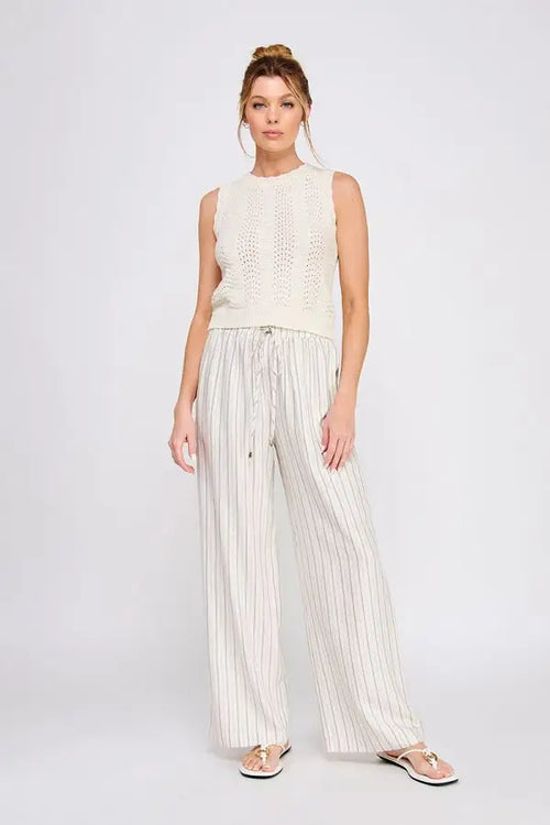 Woman wearing linen blend striped elastic tie waist pants and sleeveless knit top