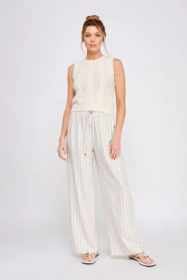 Woman wearing linen blend striped elastic tie waist pants and sleeveless knit top