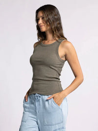 Woman showcasing the Edlin Basic Tank in olive green with light blue pants