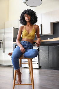 Woman in a kitchen wearing a Ribbed Lace Boho Racerback Bralette while seated