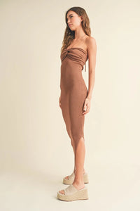 Woman in halter neck knit long slit dress with twisted bust detail and beige wedge sandals
