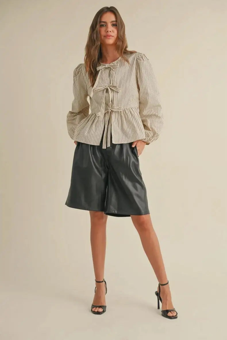 Woman in striped blouse and leather shorts showcasing women’s boho chic clothing from Shop Daisy