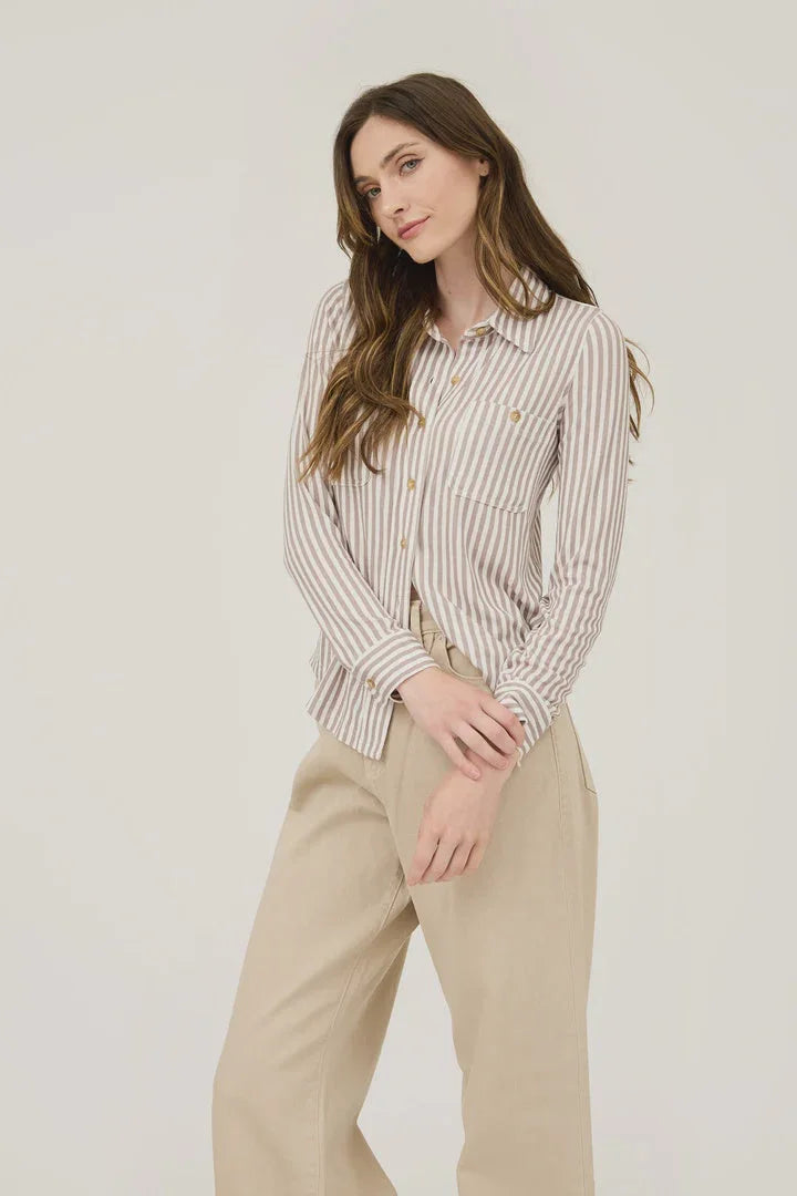 Woman in a stripe collared long sleeve button down shirt with beige pants