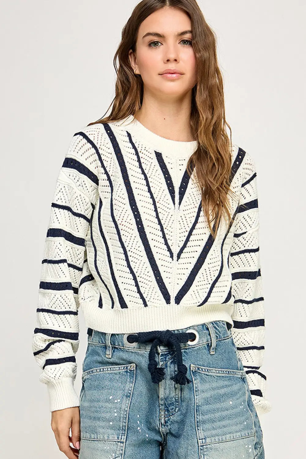 Woman wearing a V-Striped Knit Sweater, a stylish women’s boho chic clothing item at Shop Daisy