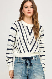 Woman wearing a V-Striped Knit Sweater, a stylish women’s boho chic clothing item at Shop Daisy