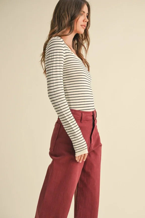 Woman in striped long-sleeve top and burgundy wide-leg pants from Shop Daisy’s women’s boho clothes