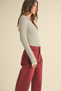 Woman in striped long-sleeve top and burgundy wide-leg pants from Shop Daisy’s women’s boho clothes