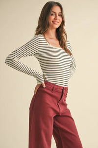 Woman in striped long-sleeve top and burgundy pants from Shop Daisy’s women’s boho chic clothing