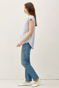Woman in striped shirt and jeans showcasing the Striped Mandarin Collar Linen Shirt from Shop Daisy