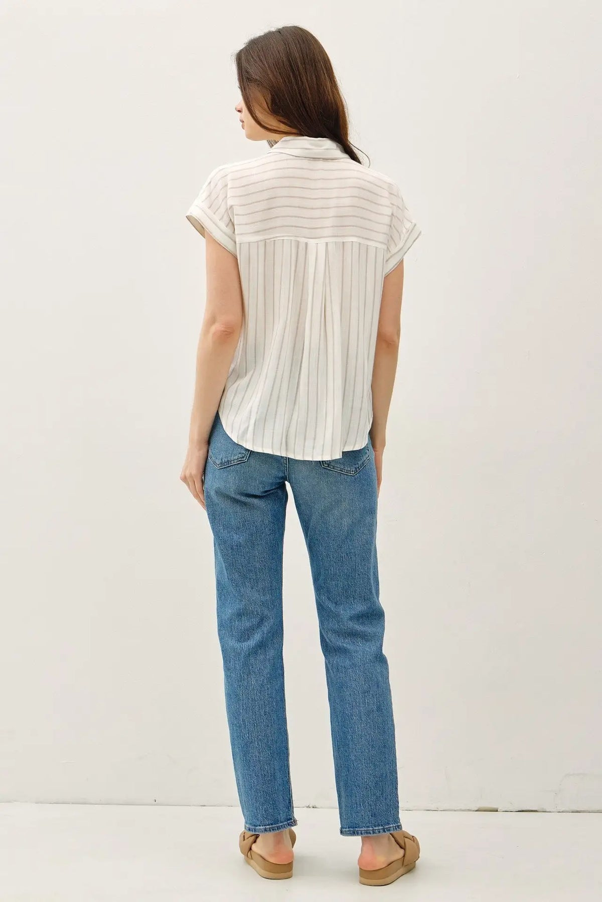 Woman wearing a stylish short sleeve striped shirt and jeans showcasing the striped shirt style