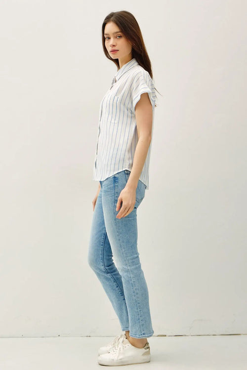 Woman wearing a stylish short sleeve striped shirt and jeans in a casual setting