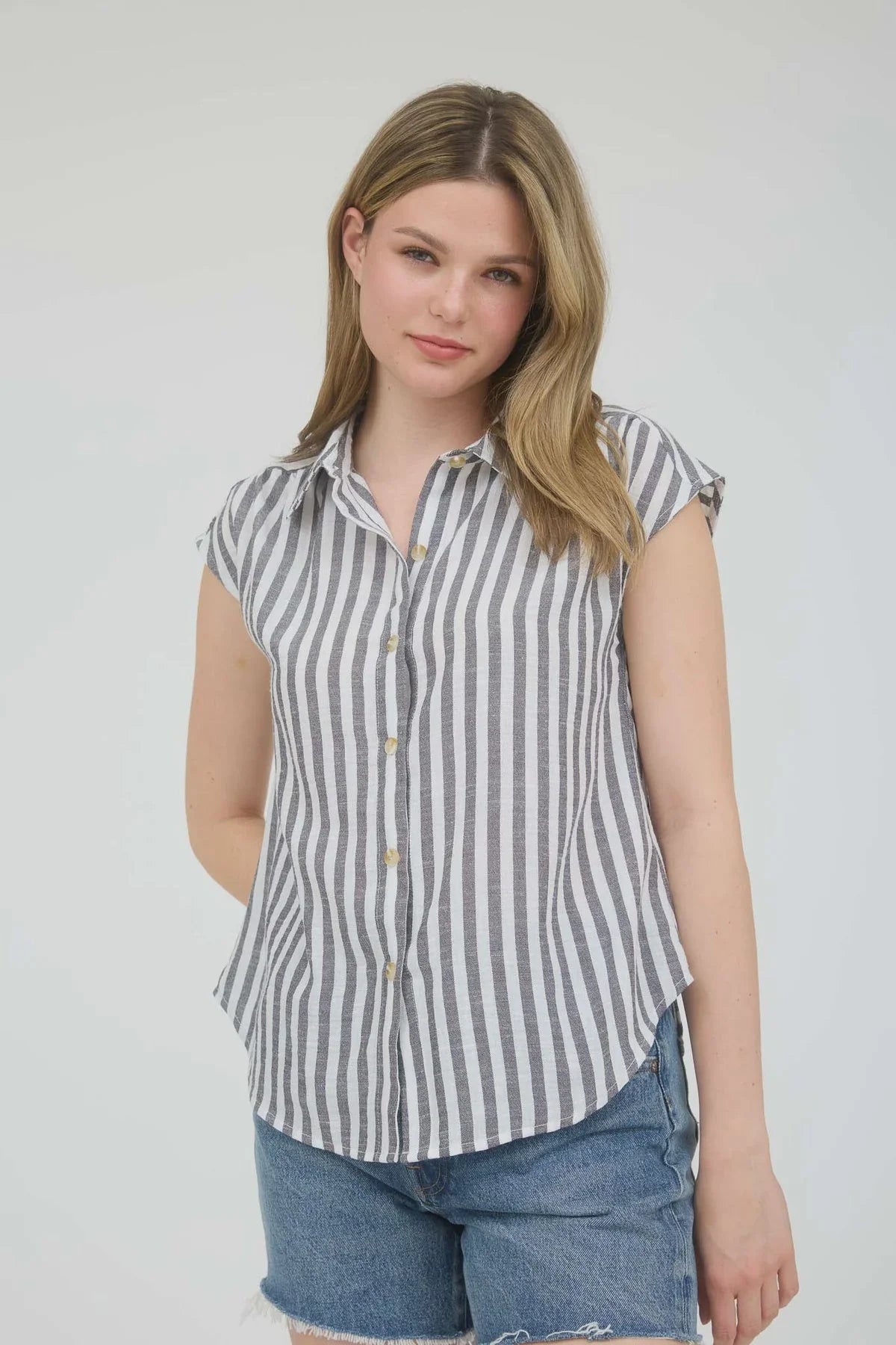 Woman wearing stripe collared short sleeve button down shirt and denim shorts