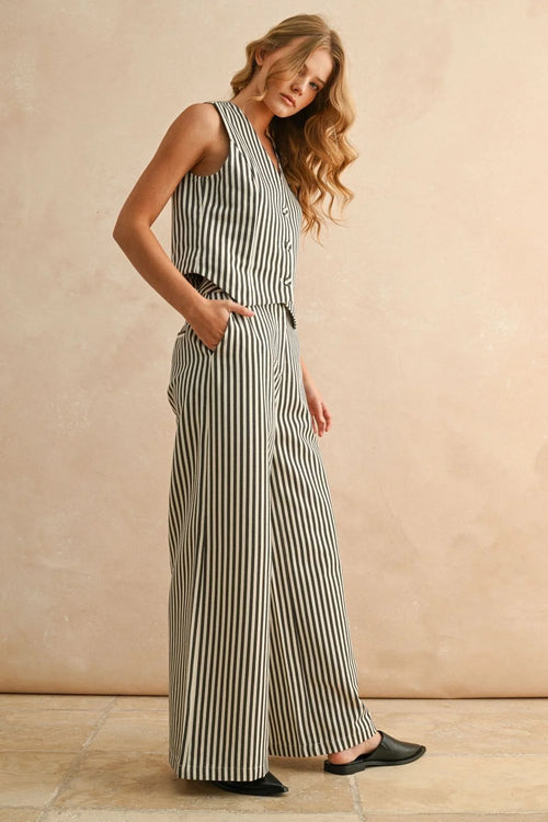 Woman wearing striped pattern wide leg pants and sleeveless top with black flats