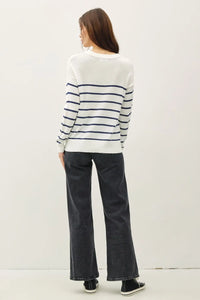 Woman wearing a stylish lightweight striped sweater with wide-leg jeans