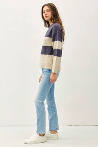 Woman in a striped pullover oversized sweater and light blue jeans