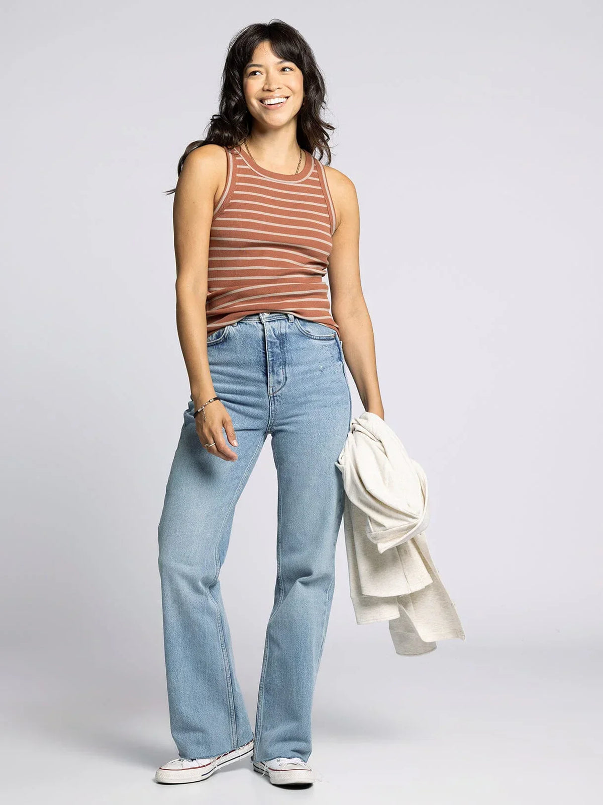 Woman wearing the Edlin Basic Tank in striped style with jeans for casual look